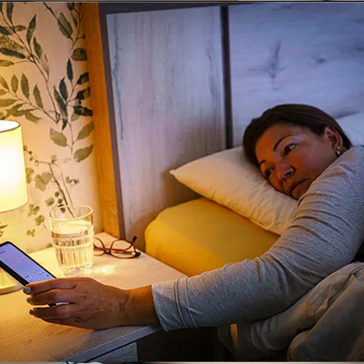 Image of a person checking their phone in bed